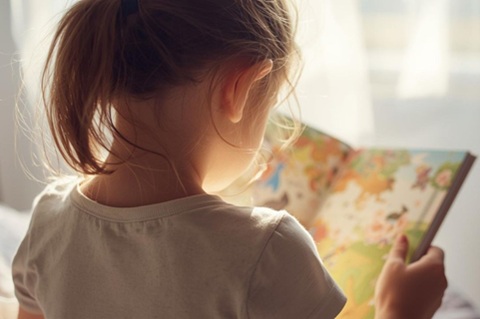 Bambina che legge (immagine creata con AI)